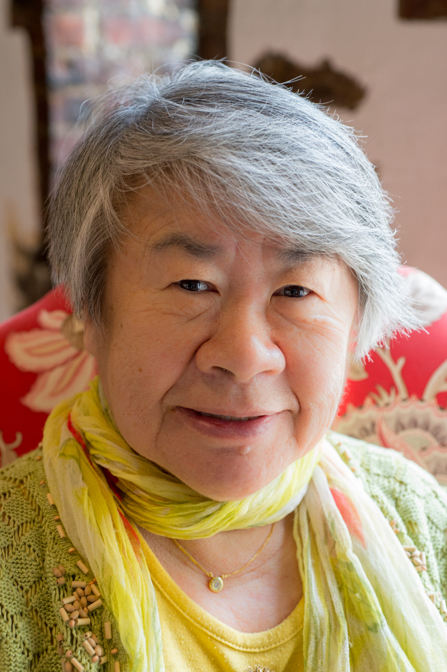 senior resident with a yellow scarf smiling at the camera
