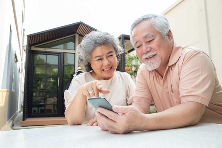 A senior couple using technology to video chat with their family.