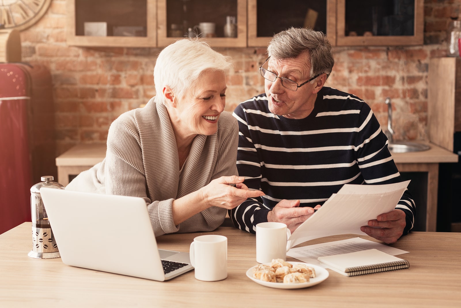 A man and woman happily going over financial statements for their retirement savings.