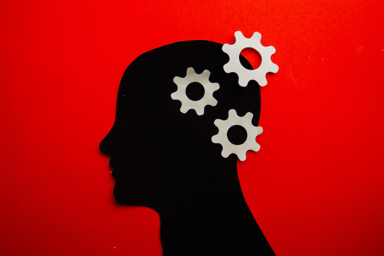 Silhouette of a human head with separated cogs representing Alzheimer’s.