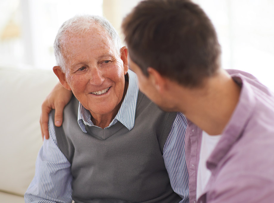 Man speaking with smiling senior parent
