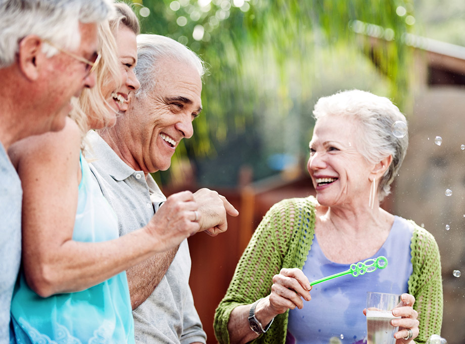 Group of seniors laughing and blowing bubbles