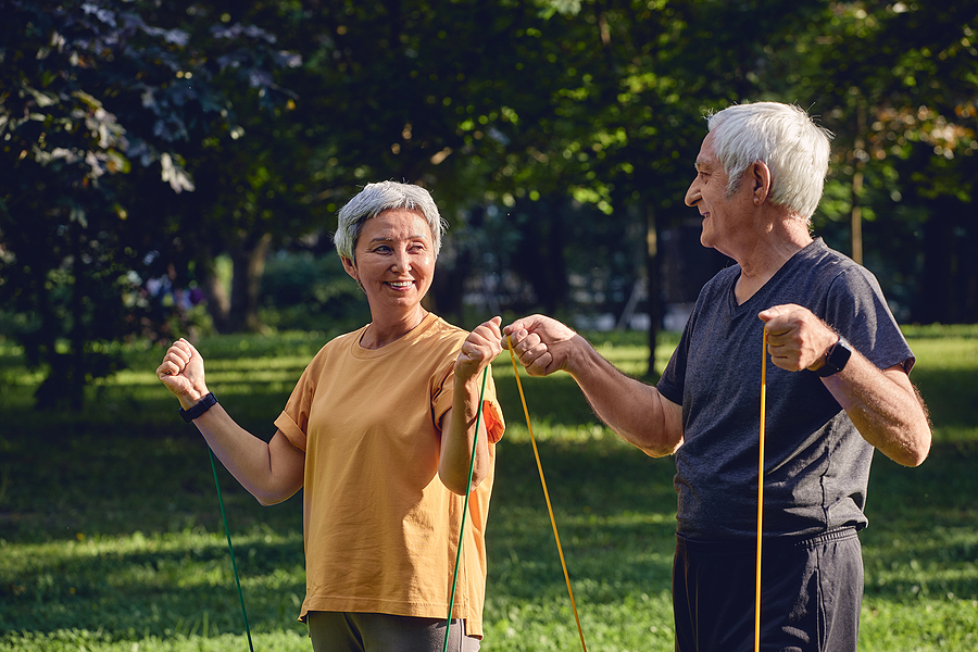 A senior couple working out together outside