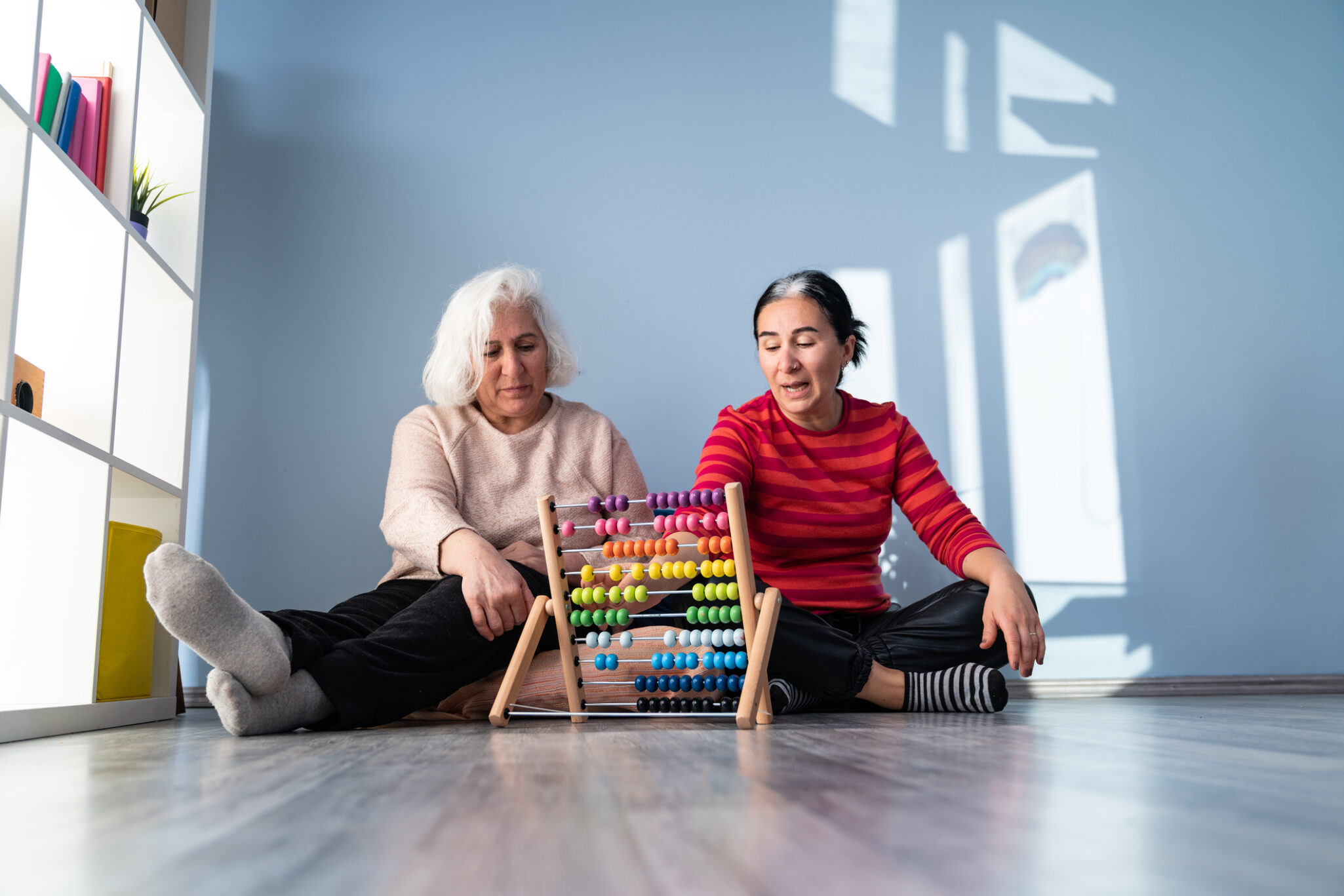 Senior Mother and Mature Adult Daughter Using Abacus