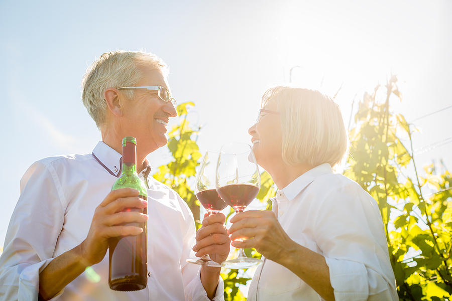 Senior Man and Woman toasting with red wine