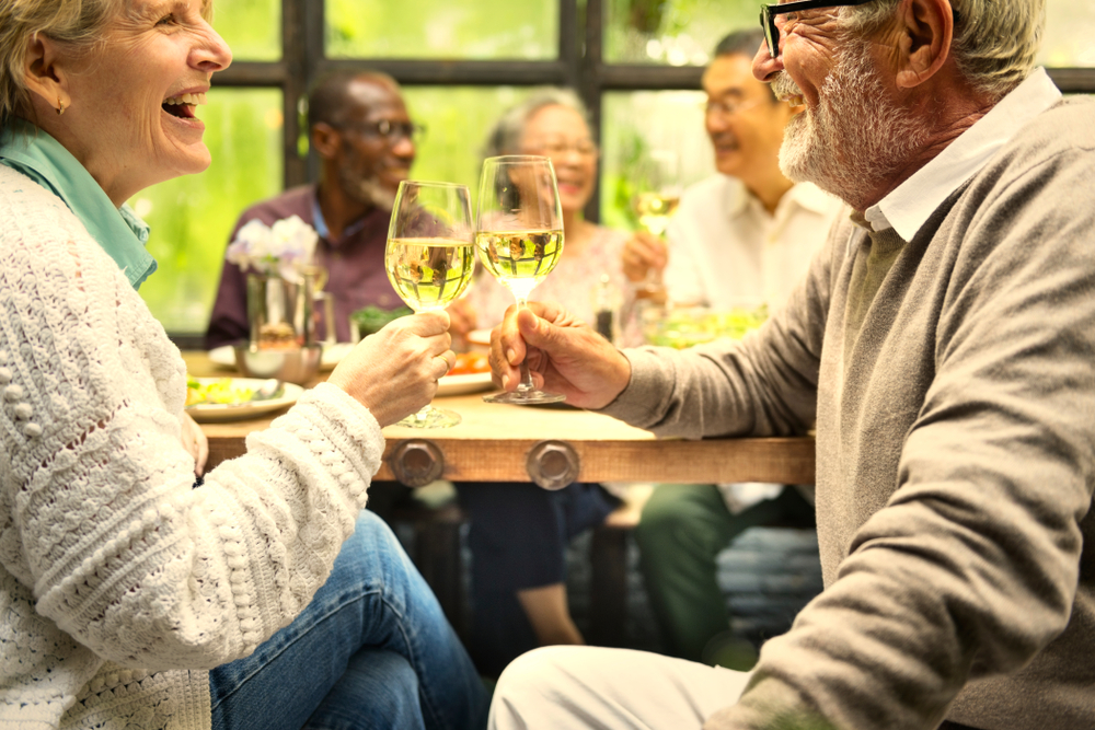 Seniors at a party with wine enjoying independent living