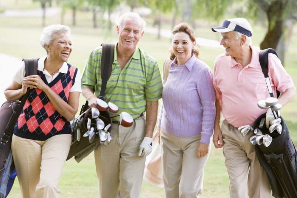 A group of senior friends enjoy a game of golf.