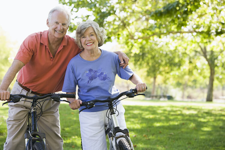 Senior couple riding their bikes and staying active as a way to boost their immune system.