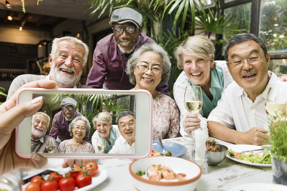 A group of seniors take a photo during dinner