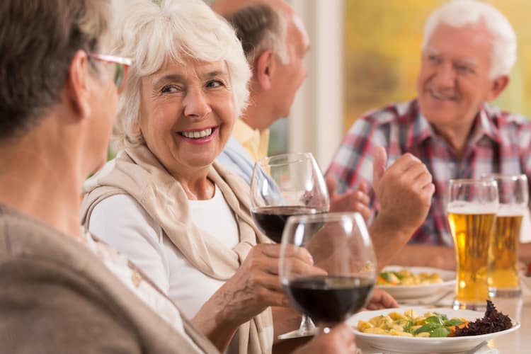 Seniors at dinner drinking wine and beer