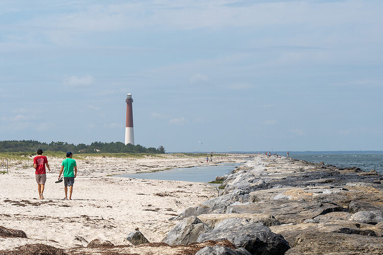 Two friends walk on the beach near Barnegat Lighthouse