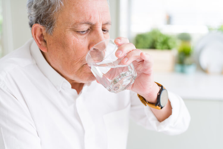 Senior man drinking a glass of water.