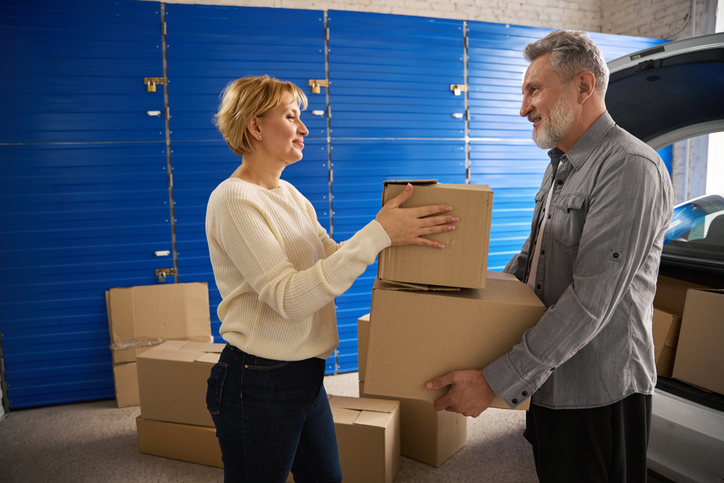 An older adult couple places items in storage before downsizing